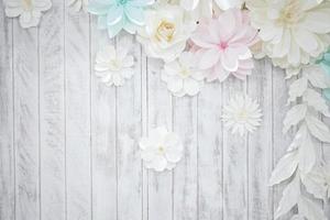 Pastel paper flower cream white pink green blue colour with hand craft art on the white wood plate background. photo