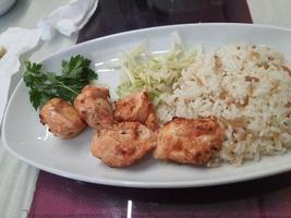 una de las comidas servidas en un pequeño hotel en turquía. que consiste en arroz con mantequilla, pollo picante y puré de patata. foto