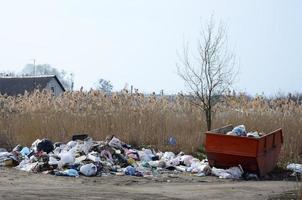 el bote de basura está lleno de basura y desechos. retiro intempestivo de basura en zonas pobladas foto