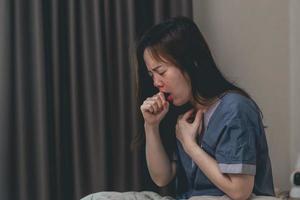 sick asian woman coughing, hiccupping, choking photo