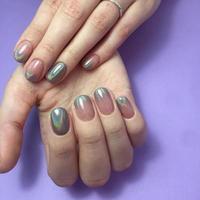 Manicure of different colors on nails. Female manicure on the hand on blue background photo