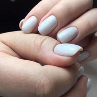 manos de mujer con uñas blancas en el fondo oscuro foto