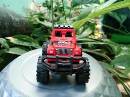 PROBOLINGGO, INDONESIA OCT. 02, 2022 miniature red jeep with a plant background photo