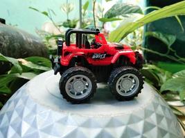PROBOLINGGO, INDONESIA OCT. 02, 2022 miniature red jeep with a plant background photo