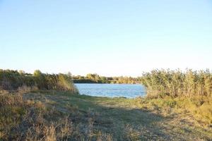 Beautiful autumn landscape with lake and multicoloral trees. Picturesque place with lake and tall trees photo