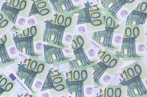 Background pattern of a set of green monetary denominations of 100 euros. A lot of money forms an infinite heap photo