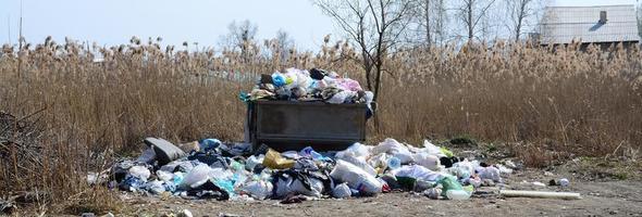 The garbage can is packed with garbage and waste. Untimely removal of garbage in populated areas photo