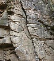 Light coarse natural rock stone background. Mining cliff rough front surface. Big limestone stack backdrop. Heavy grunge damaged granite block texture photo