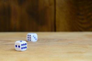 A few dice lies on the surface of natural wood. Items for generating numbers from one to six in the form of points that are painted on the side of cubes. The concept of gambling photo