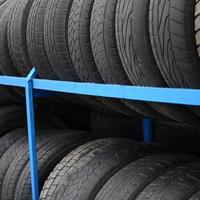 Rack with variety of car tires in automobile store. Many black tires. Tire stack background. Selective focus photo