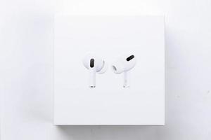 KHARKIV, UKRAINE - JANUARY 27, 2021 Apple AirPods Pro on a white background. Wireless headphones with charging case and a box. Apple Inc. is an American technology company photo