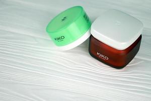 KHARKIV, UKRAINE - DECEMBER 16, 2021 Kiko Milano cream jars with company logo. Kiko Milano is an Italian cosmetics brand photo