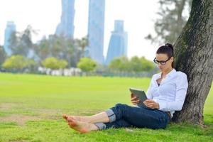 Beautiful young woman with  tablet in park photo