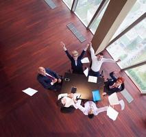 top view of business people group throwing dociments in air photo