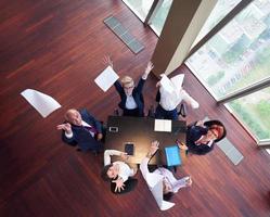 top view of business people group throwing dociments in air photo