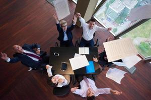 top view of business people group throwing dociments in air photo