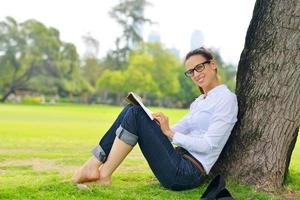 Young woman reading a book in the park photo