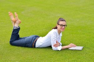 Beautiful young woman with  tablet in park photo