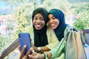african female friends using smart phone together photo