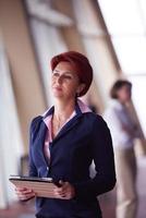 business woman  at office with tablet  in front  as team leader photo