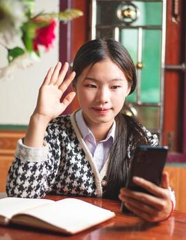 A young women student is video calling with teacher for online learning study and ask about homework, internet and virtual online learning concept, copy space for individual text photo