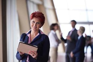 business woman  at office with tablet  in front  as team leader photo