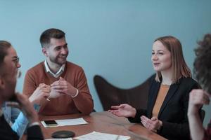 Successful team. Group of young multi-ethnic business people working and communicating together in creative office. Selective focus photo