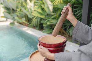 Woman hand making thai food call papaya salad or Som Tam, mixing and pounding in a mortar. photo