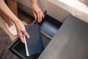 Woman hand with wooden drawer stand and note book inside. photo