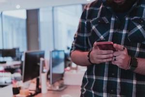 Office manager work in coworking space using smartphone analyzing online market trends, focused man worker reading financial news or browsing internet on phone. Technology concept photo