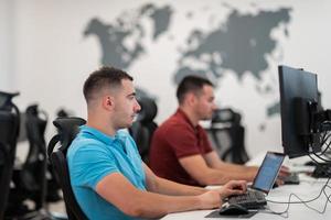 Group of Casual business man working on desktop computer in modern open plan startup office interior. Selective focus photo