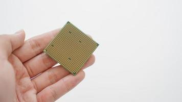 Hand holding gold computer processor on white background. photo