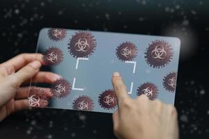Hand holding and showing virus on tablet device. photo
