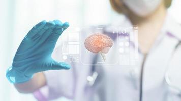 pantalla de tableta transparente del asimiento de la mano del doctor que muestra el cerebro en la pantalla foto