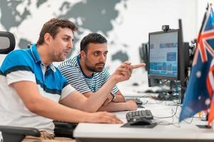 Group of Casual business man working on desktop computer in modern open plan startup office interior. Selective focus photo