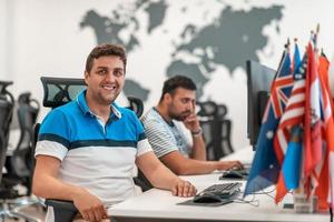 Group of Casual business man working on desktop computer in modern open plan startup office interior. Selective focus photo