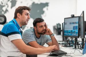 Group of Casual business man working on desktop computer in modern open plan startup office interior. Selective focus photo