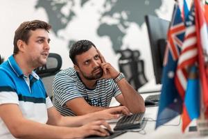 Group of Casual business man working on desktop computer in modern open plan startup office interior. Selective focus photo