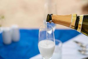 Close up Bartender pouring champagne into glass. photo