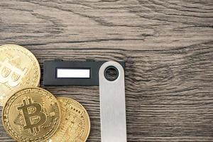 Hardware cryptocurrency wallet with golden Bitcoin BTC. Safe storage for crypto. photo