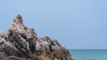 Tropical beach, rock and sand background with blue sky. photo