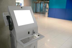 máquina de información automatizada con pantalla blanca simulada en el aeropuerto. foto
