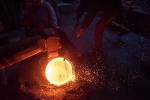 blacksmith workers using mechanical hammer at workshop photo