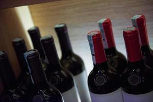 Wine bottles on a wooden shelf. photo