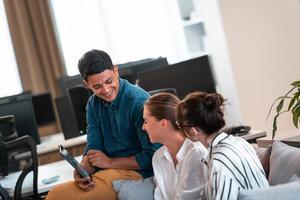 Group of casual multiethnic business people taking break from the work doing different things while enjoying free time in relaxation area at modern open plan startup office photo