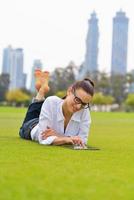 hermosa mujer joven con tableta en el parque foto