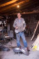 A blacksmith worker showing handmade products ready for sale photo