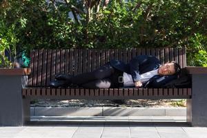 A tired Asian worker is lying in front of the company during a break from work. photo