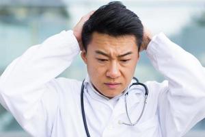 portrait of doctor asian man tired after work close up photo