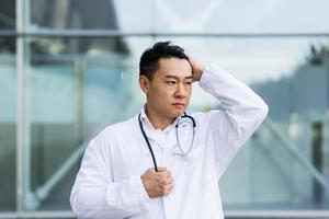 Asian doctor is tired after work, depressed and disappointed with the work done on the street photo